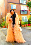Woman in a peach ruffled statement coat ready for formal event