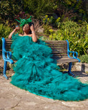 Front view of emerald tiered tulle gown showing full dramatic train and layered structure