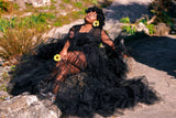 Model wearing a black St Zandas tulle maxi robe with tiered ruffles, sheer sleeves and a sweeping flowy floor-length hem
