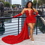 A woman models a sparkling red strapless gown with long matching sleeves, a plunging cutout bodice, and a dramatic train, posed outdoors by a waterfront railing.